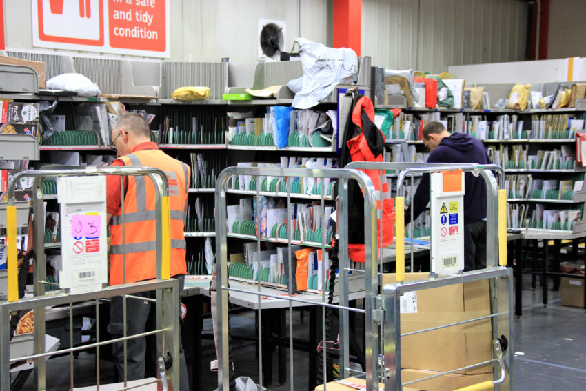 Royal Mail plans to cut 700 managerial jobs in a restructuring that has forced it to lower its profit outlook for the year.